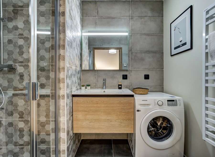 This modern bathroom features a sleek design with hexagonal tile accents and a floating wood vanity.