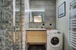 This modern bathroom features a sleek design with hexagonal tile accents and a floating wood vanity.