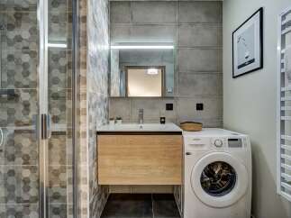 This modern bathroom features a sleek design with hexagonal tile accents and a floating wood vanity.
