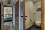 Step into a charming mountain retreat featuring rustic wooden doors and a cozy bedroom visible through an open doorway.