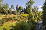 Nestled amidst lush greenery and mature trees, this property offers a serene retreat with a charming wooden lodge and a rustic cabin.