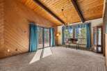 Experience rustic charm in this inviting living space featuring a vaulted wood-paneled ceiling and a cozy fireplace.