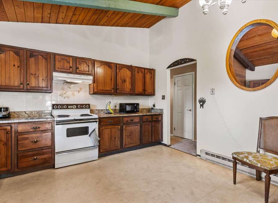 Discover this charming kitchen featuring warm wooden cabinetry and a classic white gas range.
