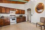 Discover this charming kitchen featuring warm wooden cabinetry and a classic white gas range.