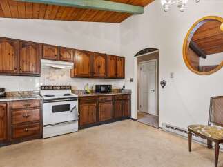 Discover this charming kitchen featuring warm wooden cabinetry and a classic white gas range.