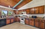 This charming kitchen boasts beautiful knotty pine cabinetry, offering ample storage and a warm, rustic aesthetic.
