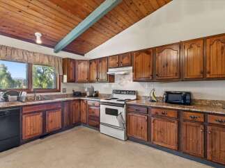 This charming kitchen boasts beautiful knotty pine cabinetry, offering ample storage and a warm, rustic aesthetic.