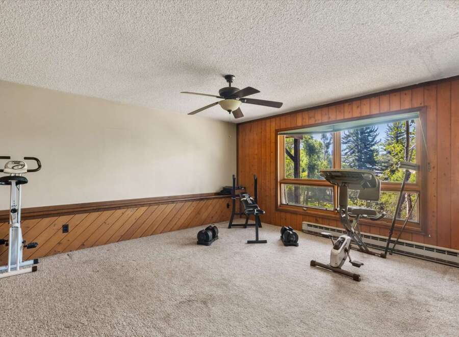 Transform this room into your personal home gym, complete with an upright exercise bike, a weight bench, and adjustable dumbbells.