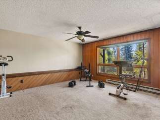 Transform this room into your personal home gym, complete with an upright exercise bike, a weight bench, and adjustable dumbbells.