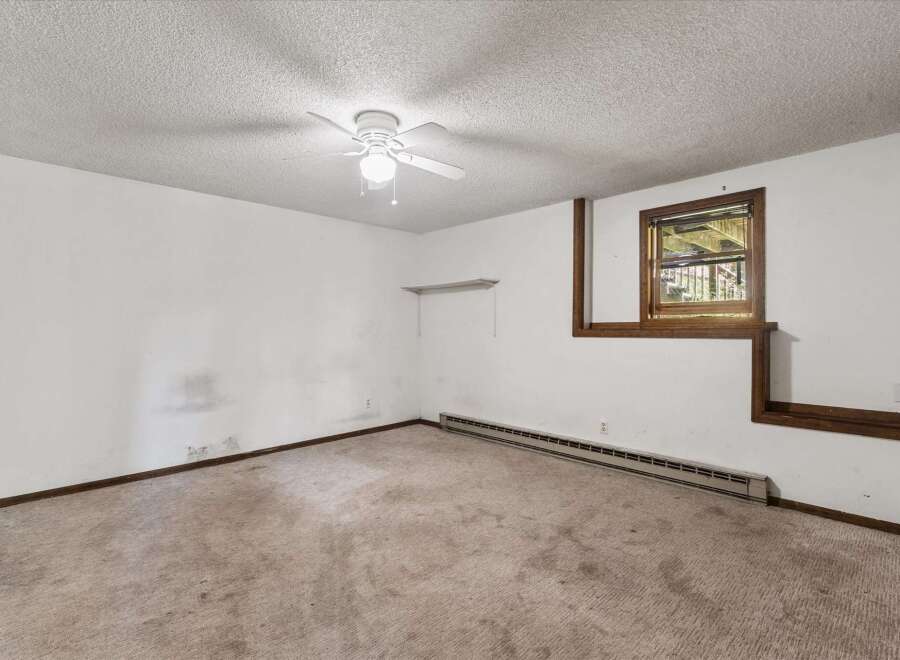 This room features a textured ceiling with a white ceiling fan, perfect for air circulation.