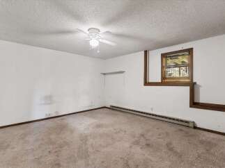 This room features a textured ceiling with a white ceiling fan, perfect for air circulation.