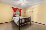 This charming bedroom features a cozy wooden bed adorned with a plush comforter and decorative pillows.