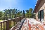 Enjoy the serene natural surroundings from this spacious wooden deck, perfect for outdoor relaxation and entertaining.