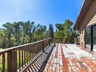 Enjoy the serene natural surroundings from this spacious wooden deck, perfect for outdoor relaxation and entertaining.
