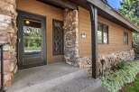 Charming mountain home featuring a rustic stone facade and warm wood siding.