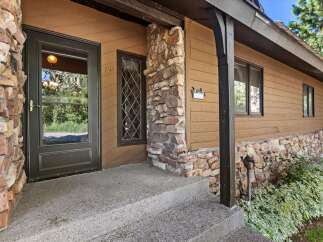 Charming mountain home featuring a rustic stone facade and warm wood siding.