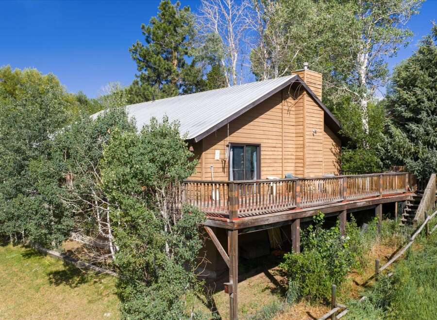 Nestled amidst lush greenery, this charming wooden cabin offers a serene retreat.