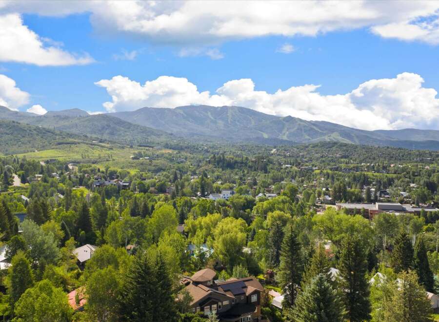 Nestled amidst lush greenery and mature trees, this property offers a serene mountain retreat with stunning views of the surrounding landscape.
