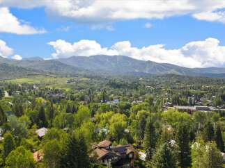 Nestled amidst lush greenery and mature trees, this property offers a serene mountain retreat with stunning views of the surrounding landscape.