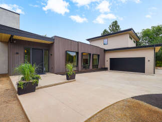 Discover modern living in this stunning home featuring a sleek, multi-level design with rich wood siding and expansive windows.