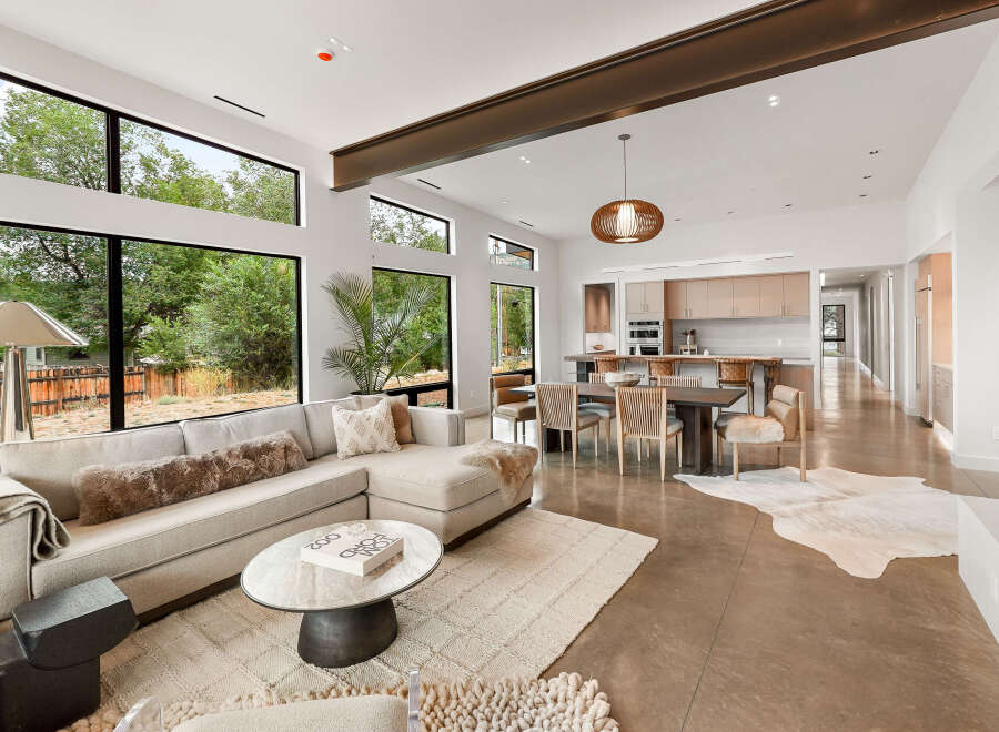 Experience modern living in this stunning open-concept home, featuring expansive windows that flood the space with natural light and offer serene views of the surrounding greenery.