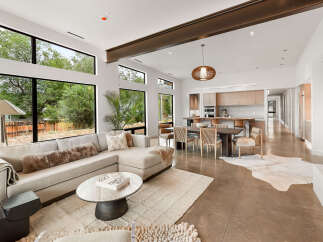 Experience modern living in this stunning open-concept home, featuring expansive windows that flood the space with natural light and offer serene views of the surrounding greenery.