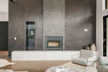 Experience modern luxury with this stunning living space featuring a sleek, textured gray fireplace as the focal point.
