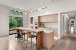 Experience modern luxury in this stunning kitchen featuring a live-edge wood island and sleek, light wood cabinetry.