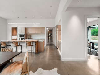 Experience modern living in this stunning open-concept home featuring a sleek kitchen with custom cabinetry and a live-edge island perfect for entertaining.