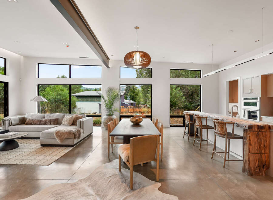 Experience modern living in this open-concept home featuring a spacious living area, a dining space, and a gourmet kitchen with a stunning live-edge bar.