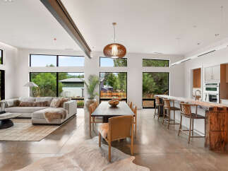 Experience modern living in this open-concept home featuring a spacious living area, a dining space, and a gourmet kitchen with a stunning live-edge bar.