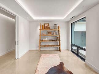 This modern living space features a unique tiered ceiling with integrated LED lighting, creating a warm and inviting ambiance.
