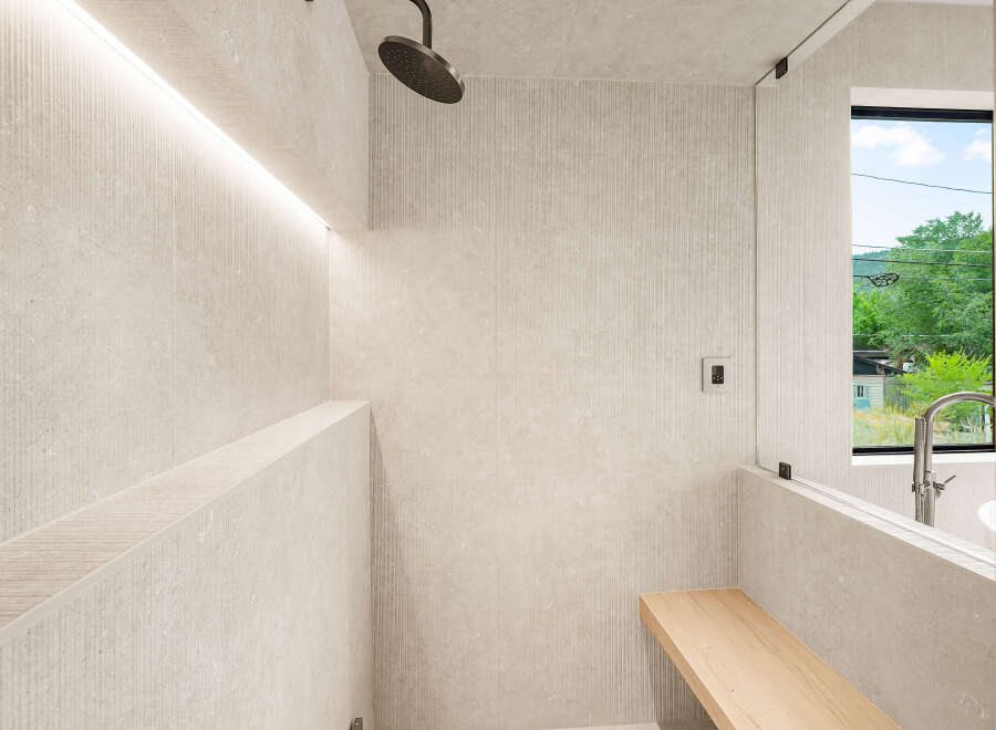 Experience modern luxury in this stunning bathroom featuring a spacious walk-in shower with elegant stone tile and integrated LED lighting.