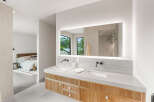 Experience modern luxury in this master bathroom featuring a sleek double vanity with marble countertops and integrated sinks.