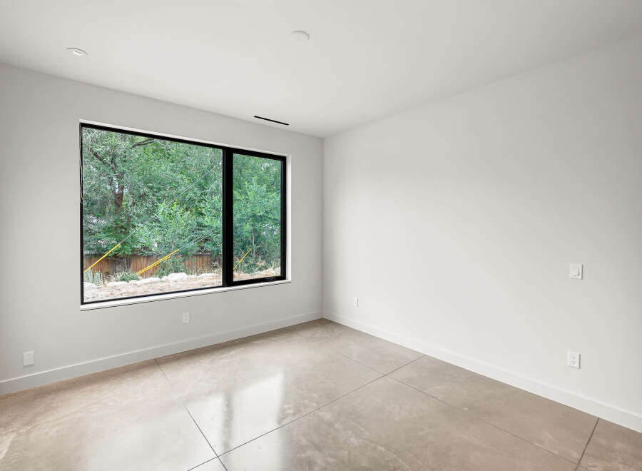 Experience modern living in this bright and airy room featuring a large picture window that floods the space with natural light.
