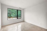 Experience modern living in this bright and airy room featuring a large picture window that floods the space with natural light.