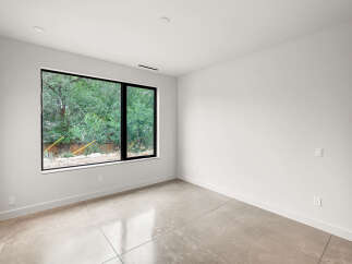 Experience modern living in this bright and airy room featuring a large picture window that floods the space with natural light.