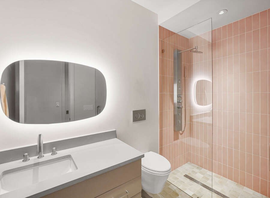 Experience modern luxury in this stunning bathroom, featuring a sleek vanity with an illuminated mirror and a spacious walk-in shower.