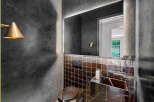Experience modern luxury in this stylish powder room, featuring a sleek marble vanity and a unique mosaic tile backsplash.