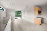 Experience modern living in this bright and airy space, featuring a sleek kitchen with stainless steel appliances and ample cabinet storage.