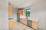 This modern kitchen features sleek, light wood cabinetry paired with crisp white countertops.