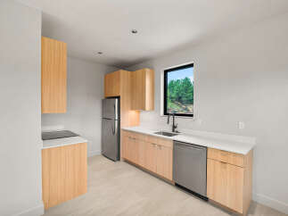 This modern kitchen features sleek, light wood cabinetry paired with crisp white countertops.