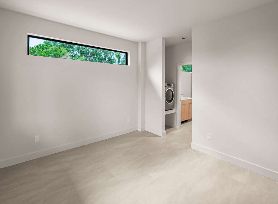 Discover modern living in this spacious room featuring a unique horizontal window that floods the space with natural light.