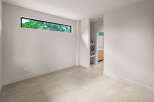 Discover modern living in this spacious room featuring a unique horizontal window that floods the space with natural light.