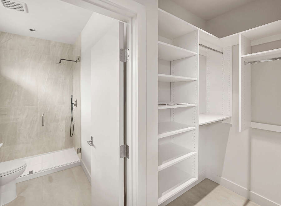 Step into this modern bathroom featuring a sleek shower with marble-look tiles and a convenient handheld showerhead.