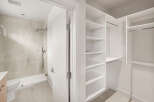 Step into this modern bathroom featuring a sleek shower with marble-look tiles and a convenient handheld showerhead.