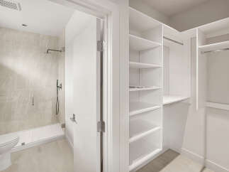 Step into this modern bathroom featuring a sleek shower with marble-look tiles and a convenient handheld showerhead.