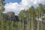 Discover a serene mountain escape with this stunning property, featuring a majestic mesa backdrop and a lush forest of aspen trees.