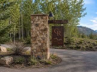 Discover the entrance to Castle Rock, a stunning property nestled amidst a serene forest landscape.