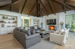 Experience luxurious living in this stunning great room, featuring a soaring vaulted wood-beamed ceiling and a magnificent stone fireplace.